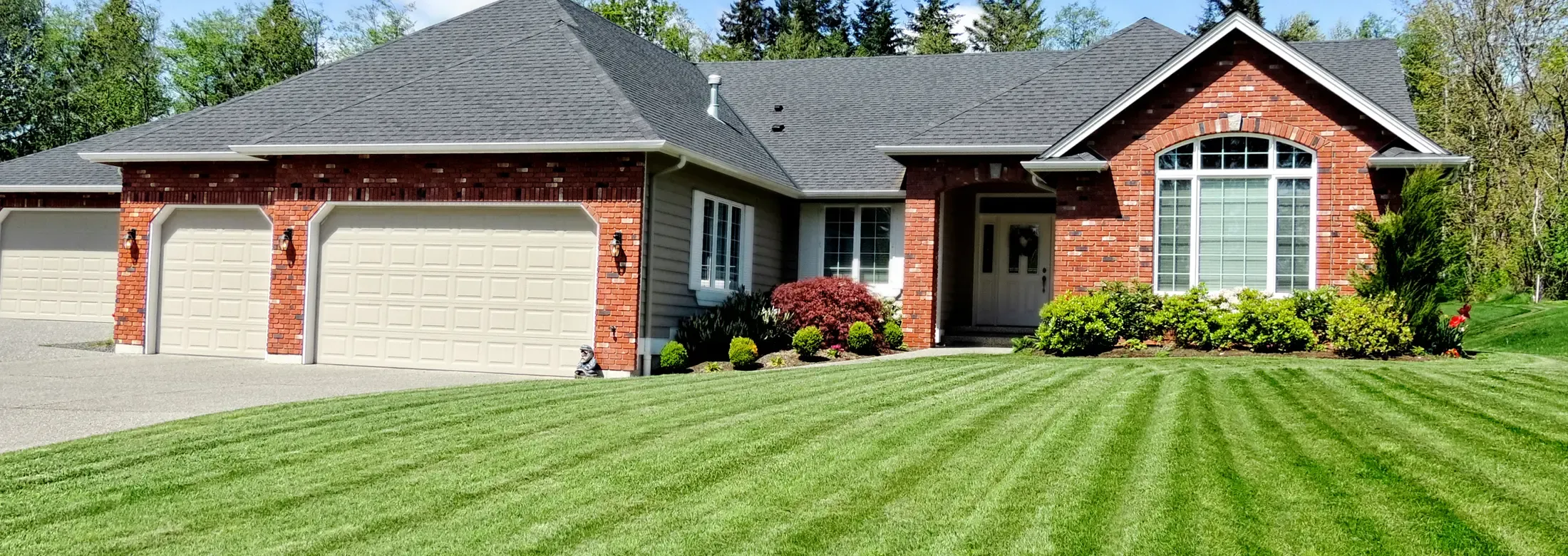 brick house with nicely mowed front lawn